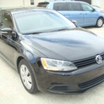 Before and after photographs of a damaged black Volkswagon Jetta that was repaired by Elite Paint & Body Shop in West Palm Beach, Florida.